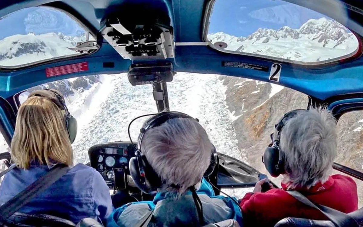 Passengers seated in a helicopter cabin with headsets on