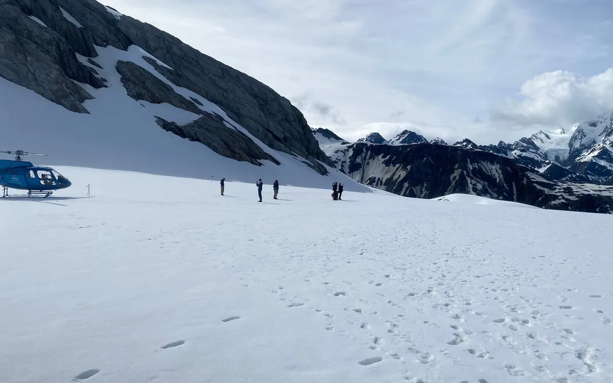 Guided walkers crossing the ice below a helicopter on Franz Josef Glacier